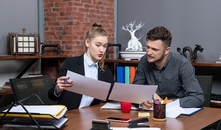 top view young busy motivated clerical workers discussing one issue documents office