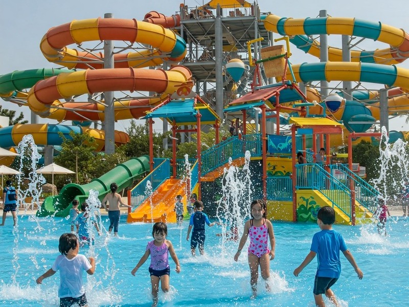 Kids playing at water theme park in Dubai with colorful slides